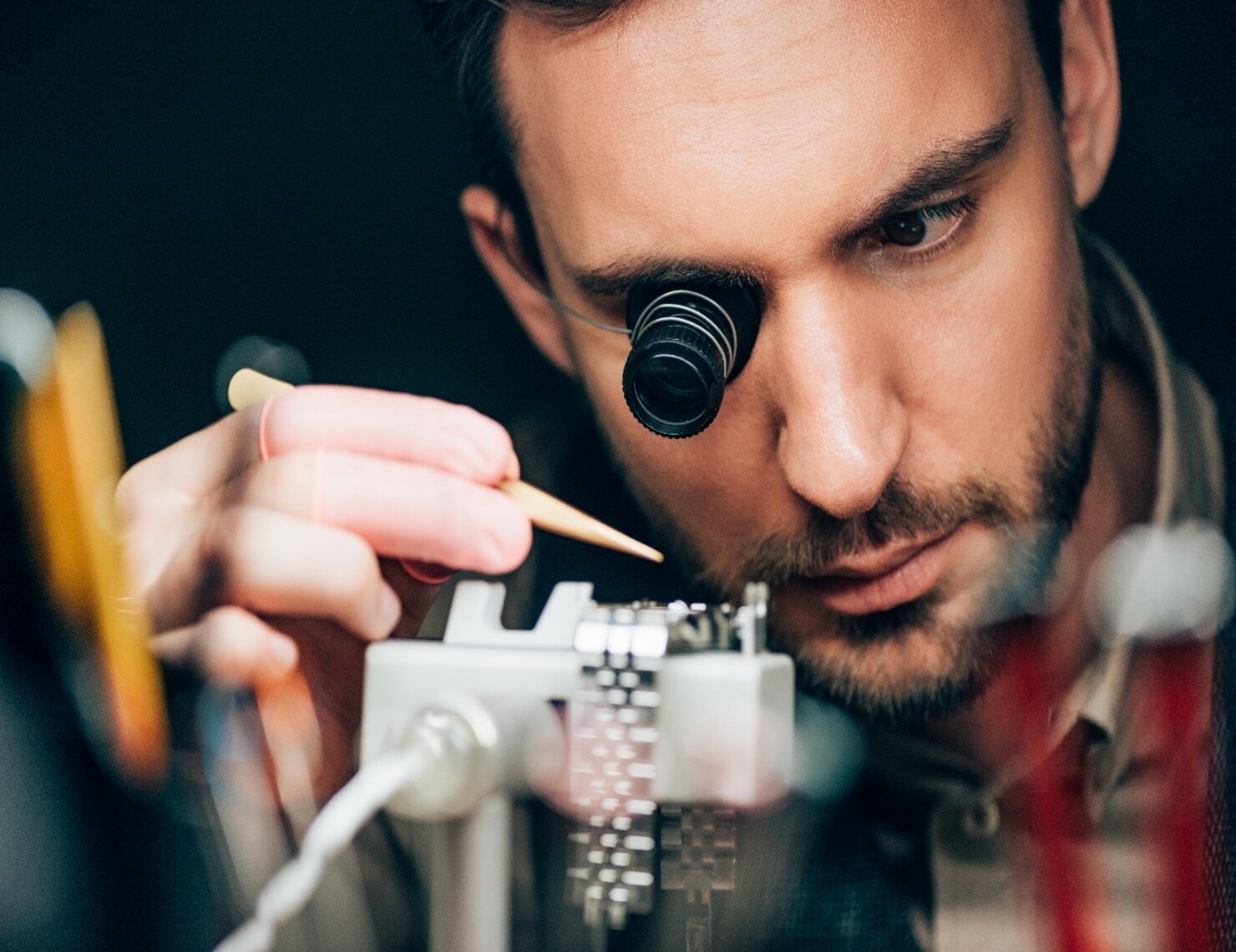man wearing specialized binoculars to repair a watch